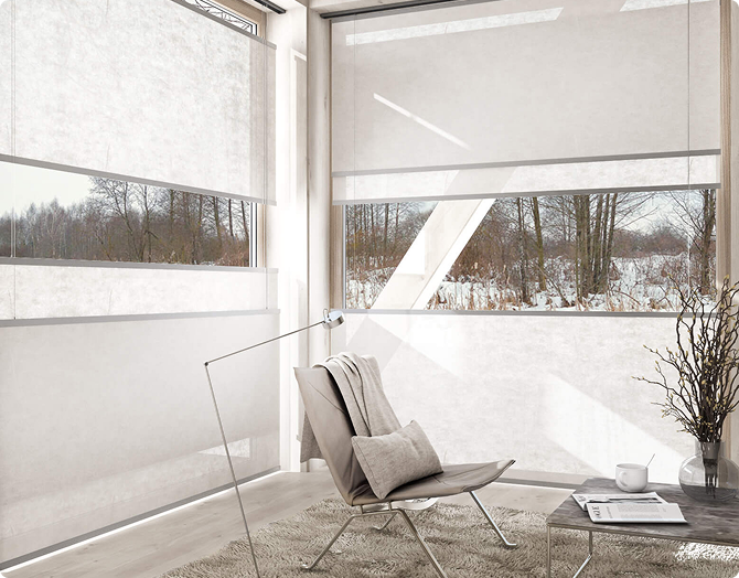 Bright modern living room with floor-to-ceiling corner windows and translucent white Flow blinds, a light gray armchair in the foreground