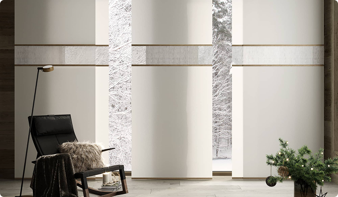 Cream panel shades with a decorative horizontal band beside a lounge chair, snowy forest outside